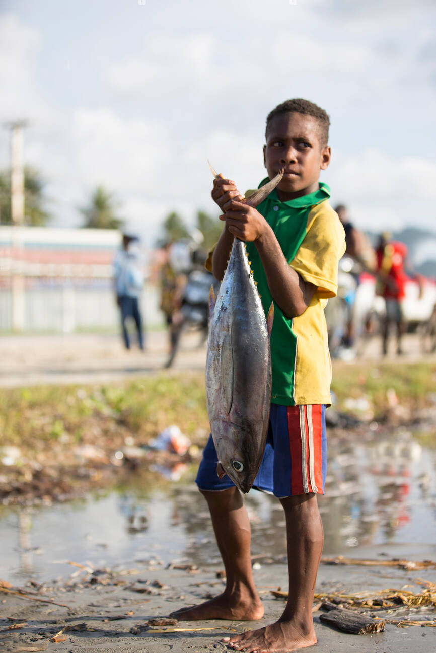 papua-new-guinea-vanimo-young-boy-in-village-with-large-fish-PAT65T